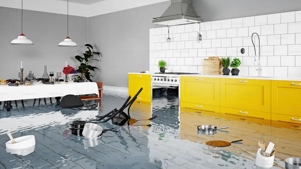 Kitchen floor flooded with overturned chairs and household items in the water